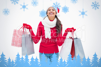 Composite image of beautiful festive woman holding shopping bags