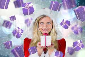 Composite image of pretty girl in santa outfit holding gift