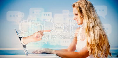 Composite image of pretty blonde using her laptop at the beach