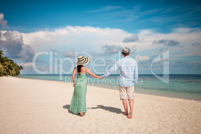 Vacation Couple walking on tropical beach Maldives.