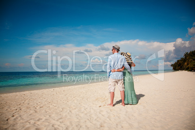 Vacation Couple walking on tropical beach Maldives.