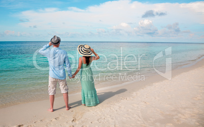 Vacation Couple walking on tropical beach Maldives.