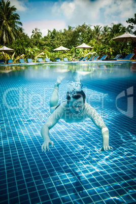 Man floats underwater in pool