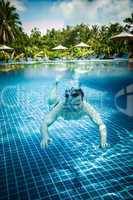 Man floats underwater in pool