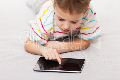 Smiling child boy playing games or surfing internet on tablet co