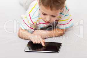 Smiling child boy playing games or surfing internet on tablet co