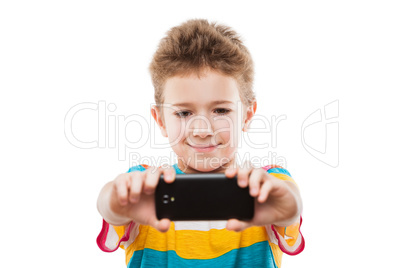 Smiling child boy holding mobile phone or smartphone taking self