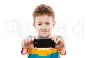 Smiling child boy holding mobile phone or smartphone taking self