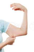Overweight woman hand holding or pinching weak flabby triceps mu