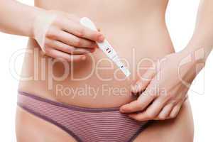 Beauty young woman hand holding pregnancy test showing two strip