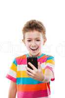 Smiling child boy holding mobile phone or smartphone taking self