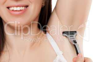Beauty smiling young woman holding razor blade shaving armpit sk