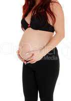 Girl holding her baby belly.