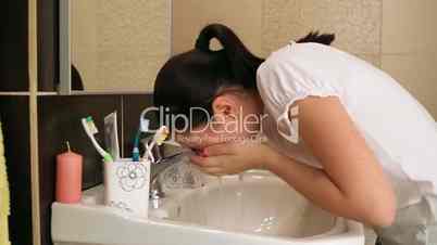 Young girl washing her face