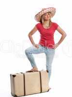 Frau mit Sombrero steht mit dem Fuß auf einem Koffer