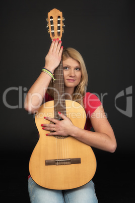 Verträumte Frau hält eine Gitarre
