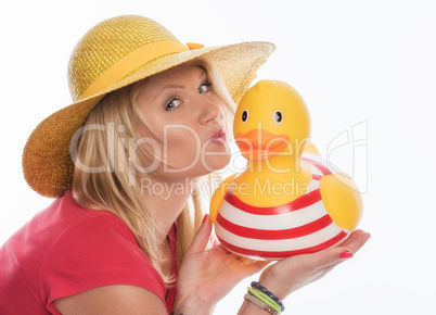 Blonde Frau mit Strohhut küsst eine Badeente