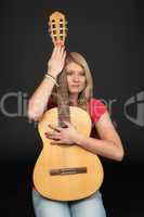 Hübsche blonde Frau hält eine Gitarre
