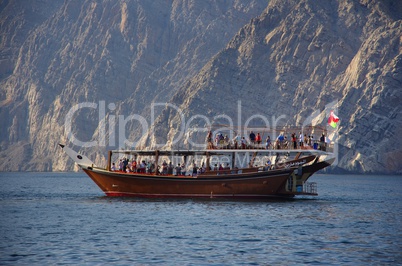 Mit dem Schiff einer Dhau in den Vereinigten Arabischen Emiraten vor den Bergen