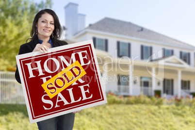 Woman Holding Sold Home Sale Sign in Front of House