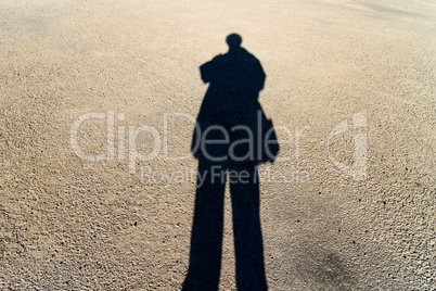 Elongated Shadow of a Person Standing on the Road