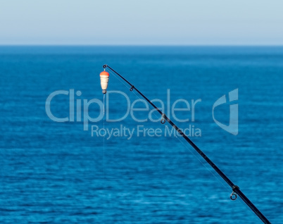 Fishing Bait-Rod with Float against the Blue Sea Water Surface