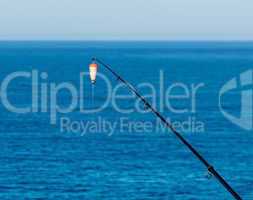 Fishing Bait-Rod with Float against the Blue Sea Water Surface