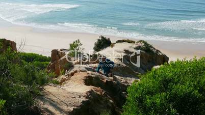 Man Climb on a Cliff Above the Ocean, sunny day