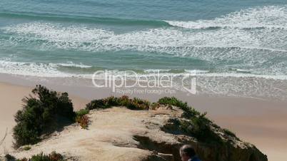 Man Climb on a Cliff Above the Ocean, sunny day