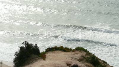 Man Climb on a Cliff Above the Ocean, sunny day