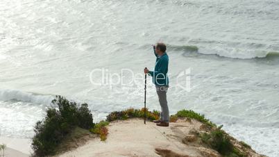 Man Climb on a Cliff Above the Ocean, sunny day