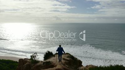 Man Climb on a Cliff Above the Ocean, sunny day