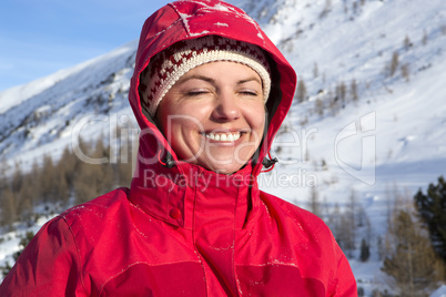 Woman with red jacket is happy to be in the mountains