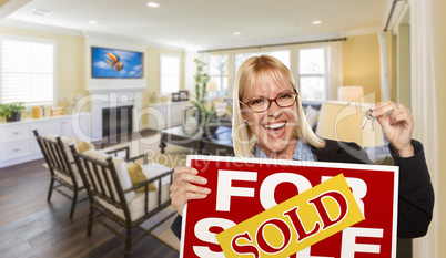 Young Woman Holding Sold Sign and Keys Inside Living Room