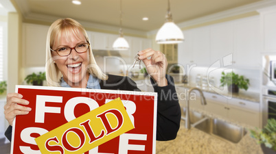 Young Woman Holding Blank Sign and Keys Inside Kitchen