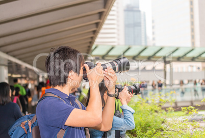 Asian photographers taking pictures of Hong Kong skyline