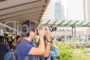 Asian photographers taking pictures of Hong Kong skyline