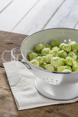 Brussels sprouts in a sieve on a table