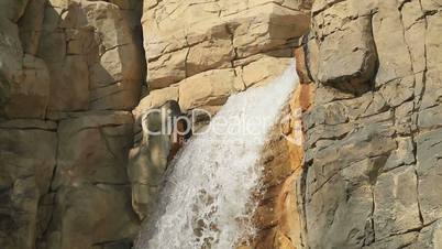 Waterfall emerging from huge rocks