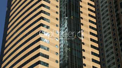 Washers wash the windows of skyscraper.