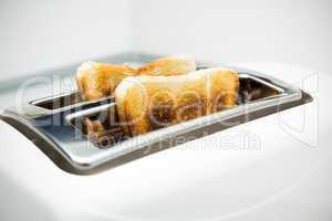 Toaster with bread slices on white background