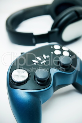 Gamepad and headphones on white background