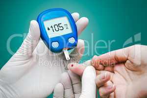 Doctor making blood sugar test. Hands with gloves on medical background