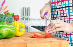 Woman chef cutting peppers. Food preparation in modern kitchen