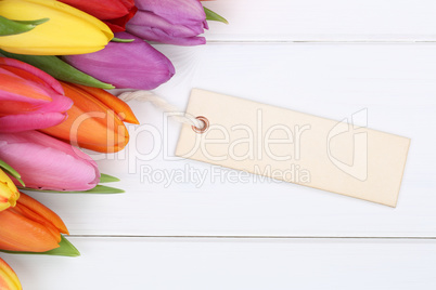 Tulpen Blumen im Frühling oder Muttertag mit Karte auf Holzbret