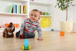 Lachendes Baby Kind beim Spielen mit Spielzeug