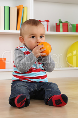 Baby Kind beim Essen einer Orange Frucht