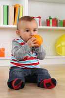Baby Kind beim Essen einer Orange Frucht