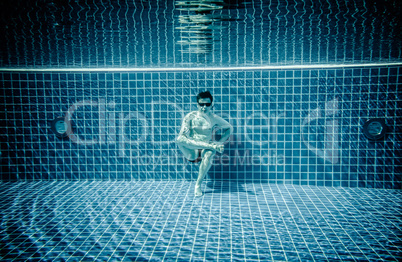 Persons lies under water in a swimming pool