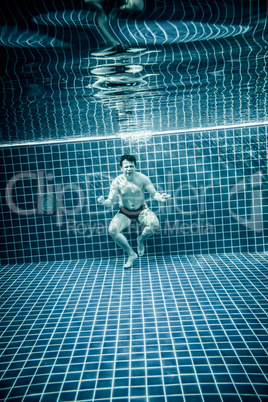 Persons standing under water in a swimming pool